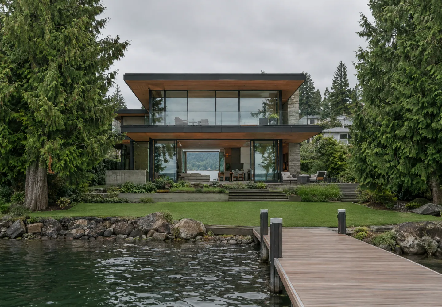 New-build lakefront home with a flat roof and full-height glass